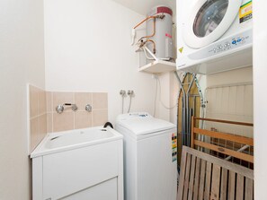 A laundry area with a washing machine, dryer, and a water heater.