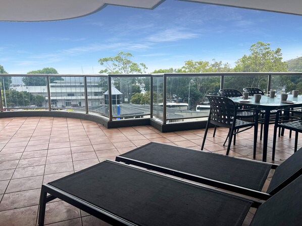 Un espacio de estar techado al aire libre con vistas a un estacionamiento y edificios.