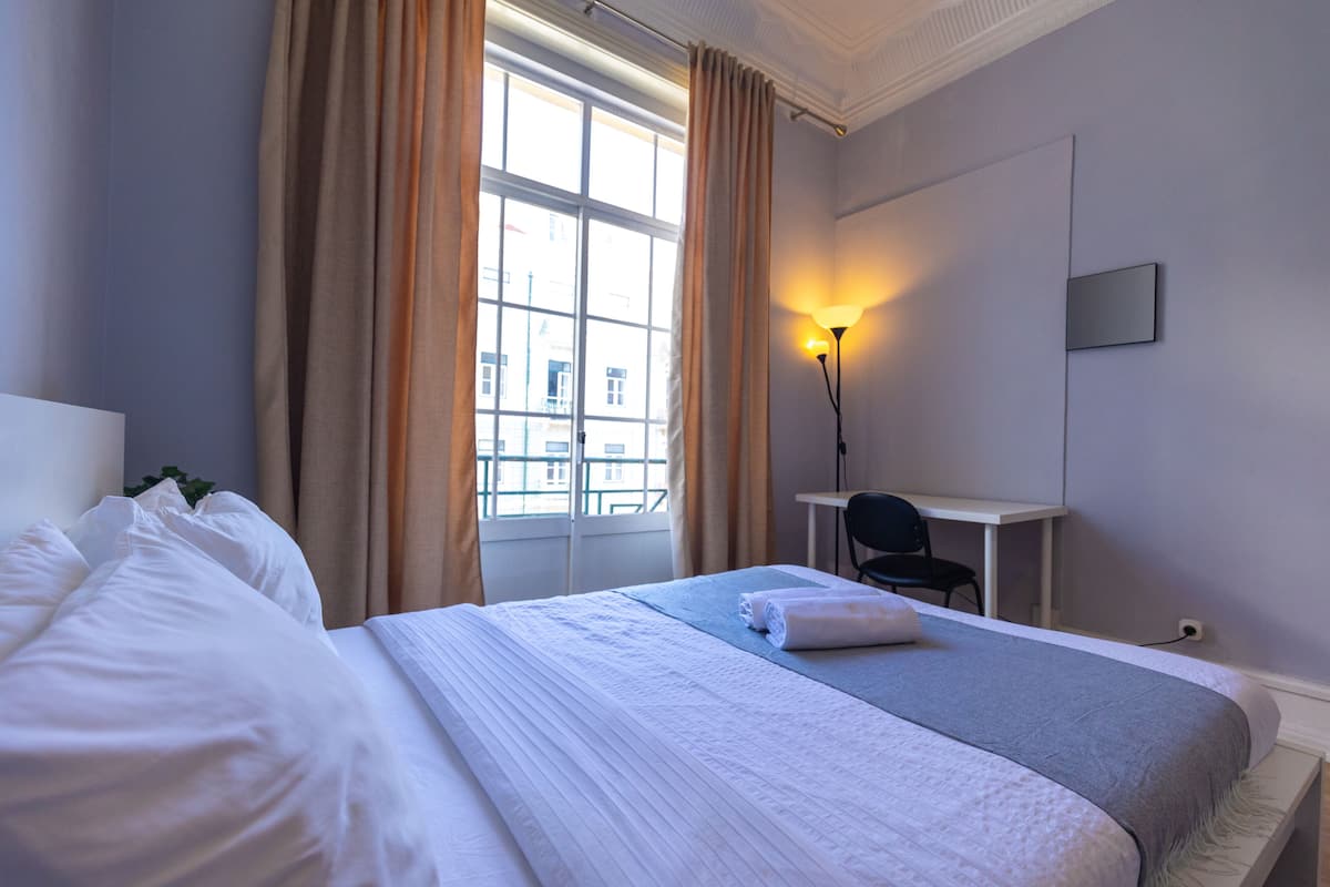 Una habitación de hotel con una cama grande, un escritorio y una silla.