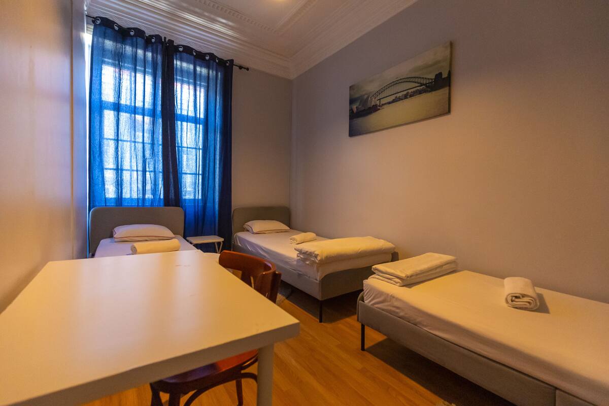 Una habitación con una cama individual, un escritorio y una silla.