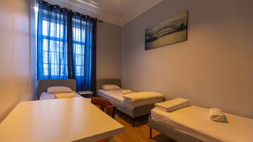 A room with a single bed, a desk, and a chair.