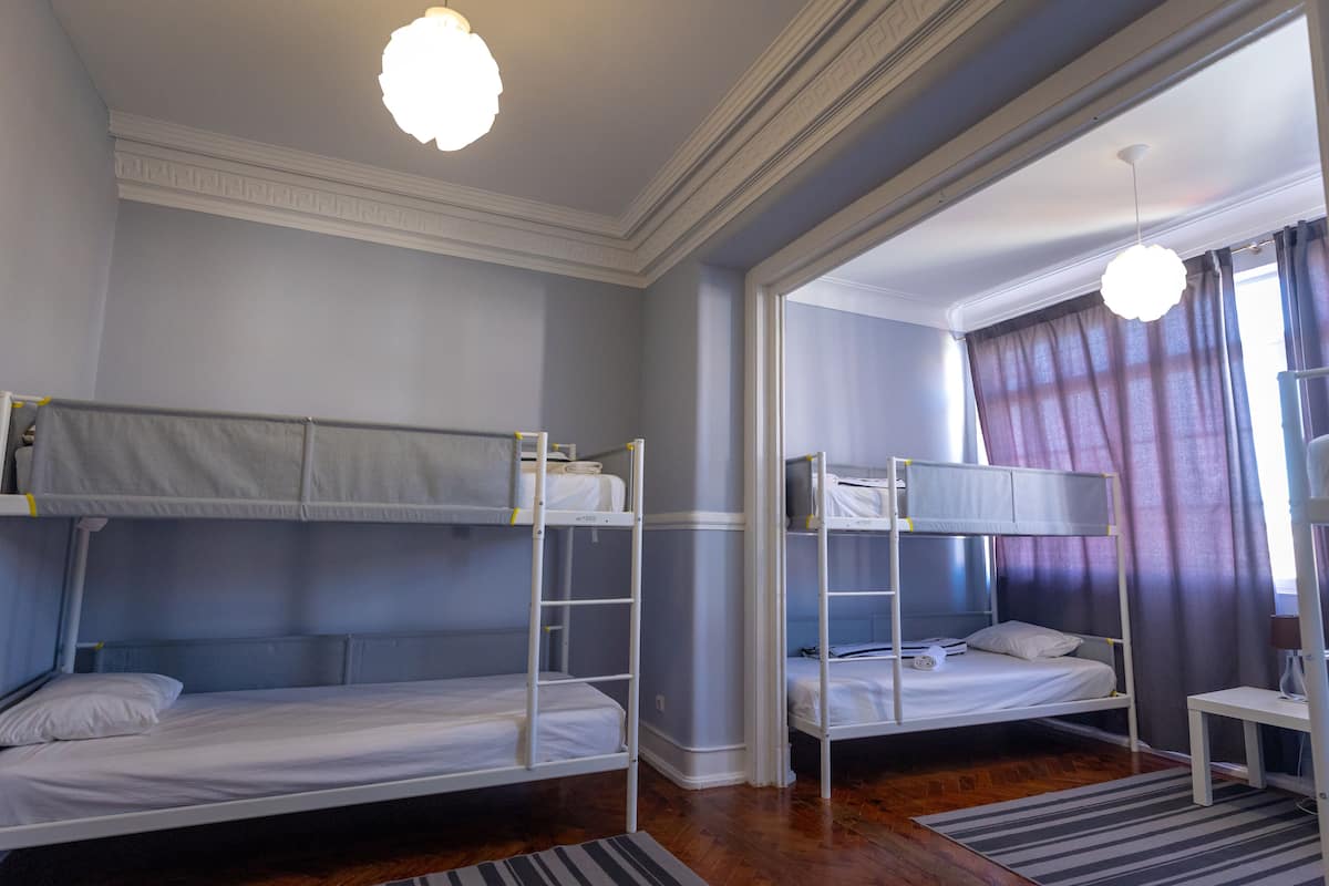 Una habitación con literas, una mesita y una lámpara.
