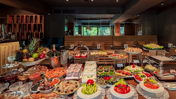 A buffet with various food items and a wine cooler. - Folk Boutique Hotel (Tbilisi)