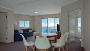 Un soggiorno moderno con zona pranzo, ampie finestre e vista sul mare.