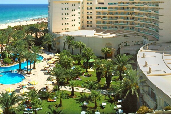A resort with a pool, palm trees, and a beach view. - Riadh Palms Resort & Spa (Sousse)