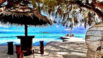 Playa privada, playa de arena blanca, camastros y sombrillas