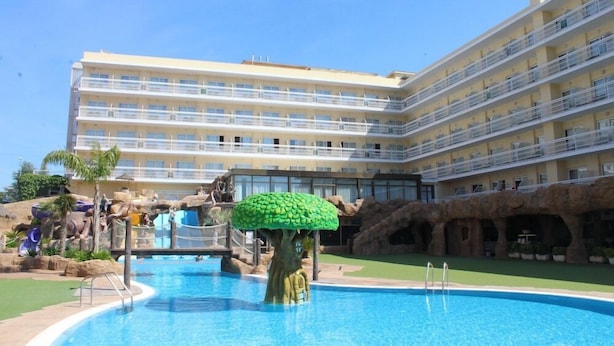 A hotel with a swimming pool, a rock formation, and a tree sculpture. - Evenia Olympic Resort - Olympic Park (Lloret de Mar)