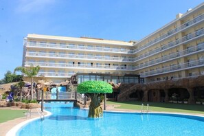 A hotel with a swimming pool, a rock formation, and a tree sculpture. - Evenia Olympic Resort - Olympic Park (Lloret de Mar)