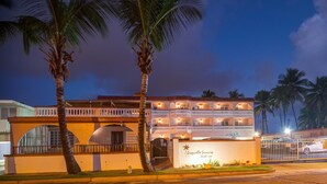 A multi-story hotel with a balcony on the second floor, palm trees in the foreground, and a sign that reads "Laquillo Sunrise Beach Resort". - Luquillo Sunrise beach Inn (Luquillo)