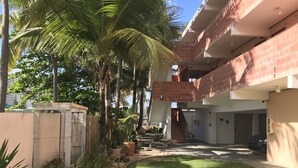 A courtyard with a grassy area, potted plants, and a staircase leading to an upper level. - Luquillo Sunrise beach Inn (Luquillo)