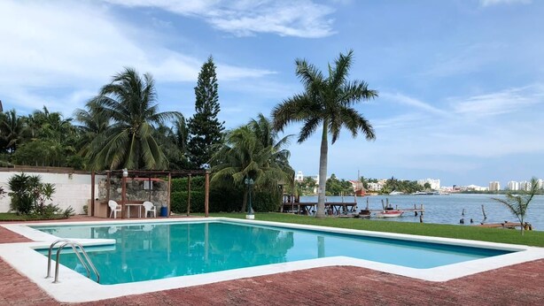 Una piscina rectangular amb una escala metàl·lica, envoltada d'un paviment de rajola.