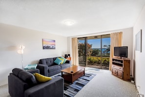 A modern living room with a sofa, coffee table, and television.