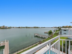 A waterfront property with a dock, a pool, and a view of the water.