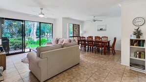 Un amplio espacio habitable con sofá, mesa de comedor, sillas y estantería.
