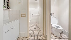 Een moderne badkamer met een witte wastafel, spiegel en toilet.