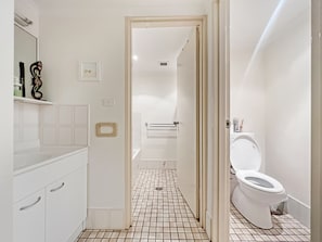 A modern bathroom with a white sink, mirror, and toilet.