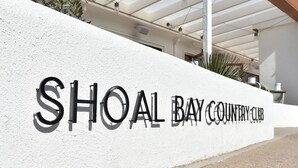 A white wall with the text 'SHOAL BAY COUNTRY CLUB' in black letters.