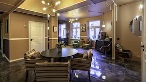 Un comedor espacioso con una mesa redonda y sillas a rayas, una cocina con electrodomésticos modernos y un espejo grande en la pared.