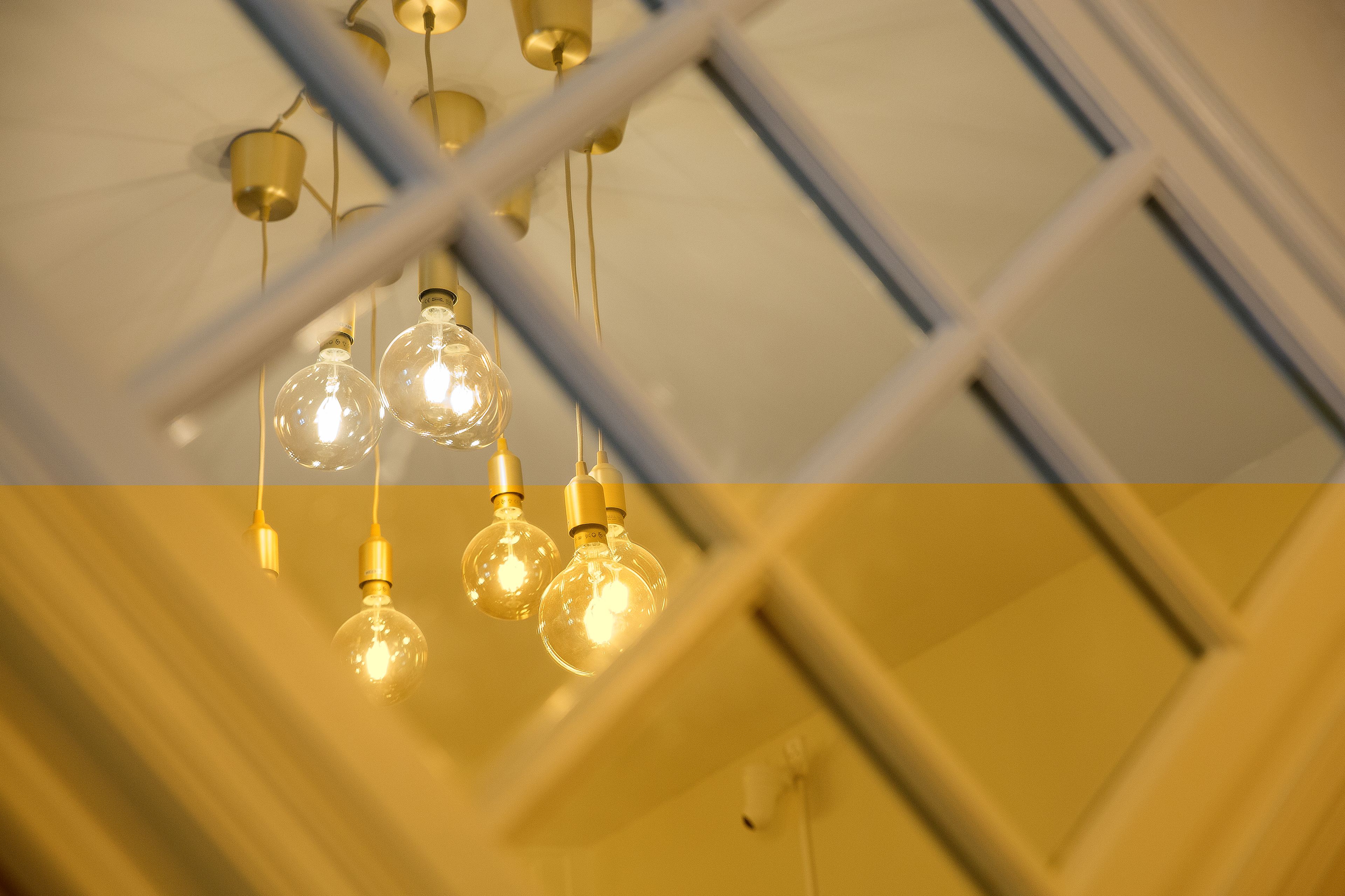 A ceiling with hanging light fixtures and a window with a grid pattern.