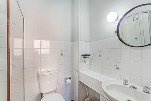 Ein Badezimmer mit Toilette, Waschbecken und Spiegel.