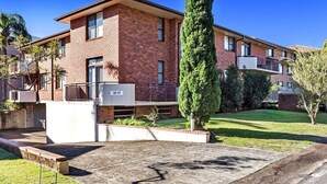 Un palazzo di mattoni a due piani con un piccolo balcone al piano terra.