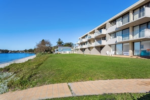 A modern hotel with a pool, a well-maintained lawn, and a clear view of the sea. - Harbourside apartment at Soldiers Point (Soldiers Point)