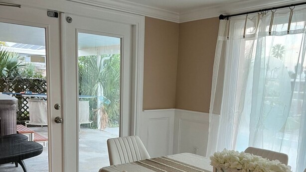 A dining area with a table set for two, a wicker chair, and a bench outside. - water front,pool,hot tub,fishing,close to beaches (new port richey)