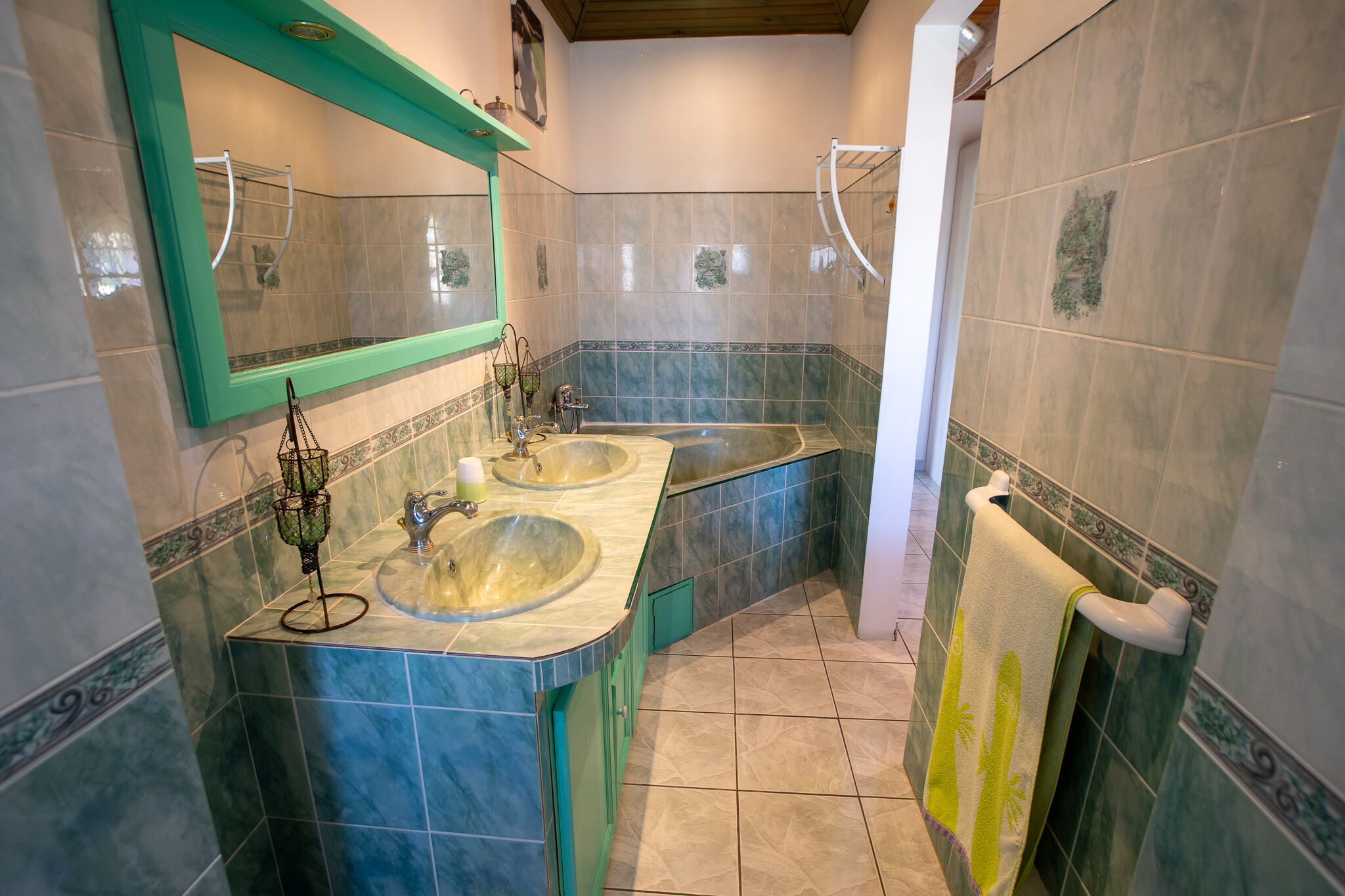 Une salle de bain avec deux lavabos, un miroir et un porte-serviettes.
