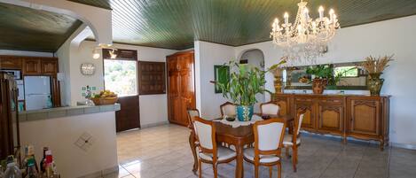 A spacious kitchen with wooden cabinets, a dining table with chairs, and a chandelier.