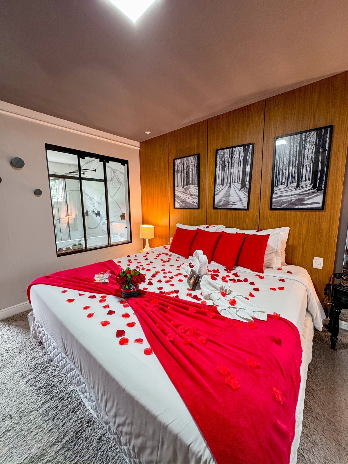 Una habitación de hotel con una cama grande, una ventana con vistas y tres cuadros en la pared.
