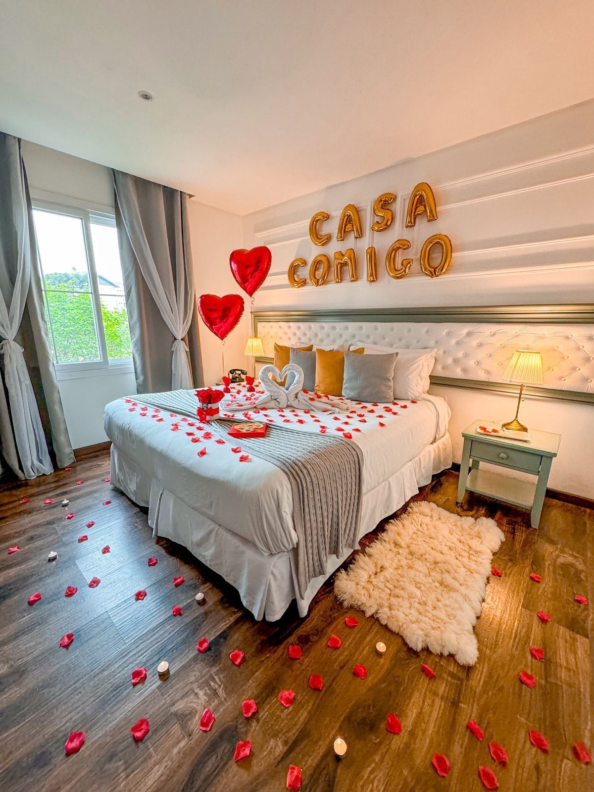 A bedroom with a bed, a nightstand, a lamp, and a wall decoration.