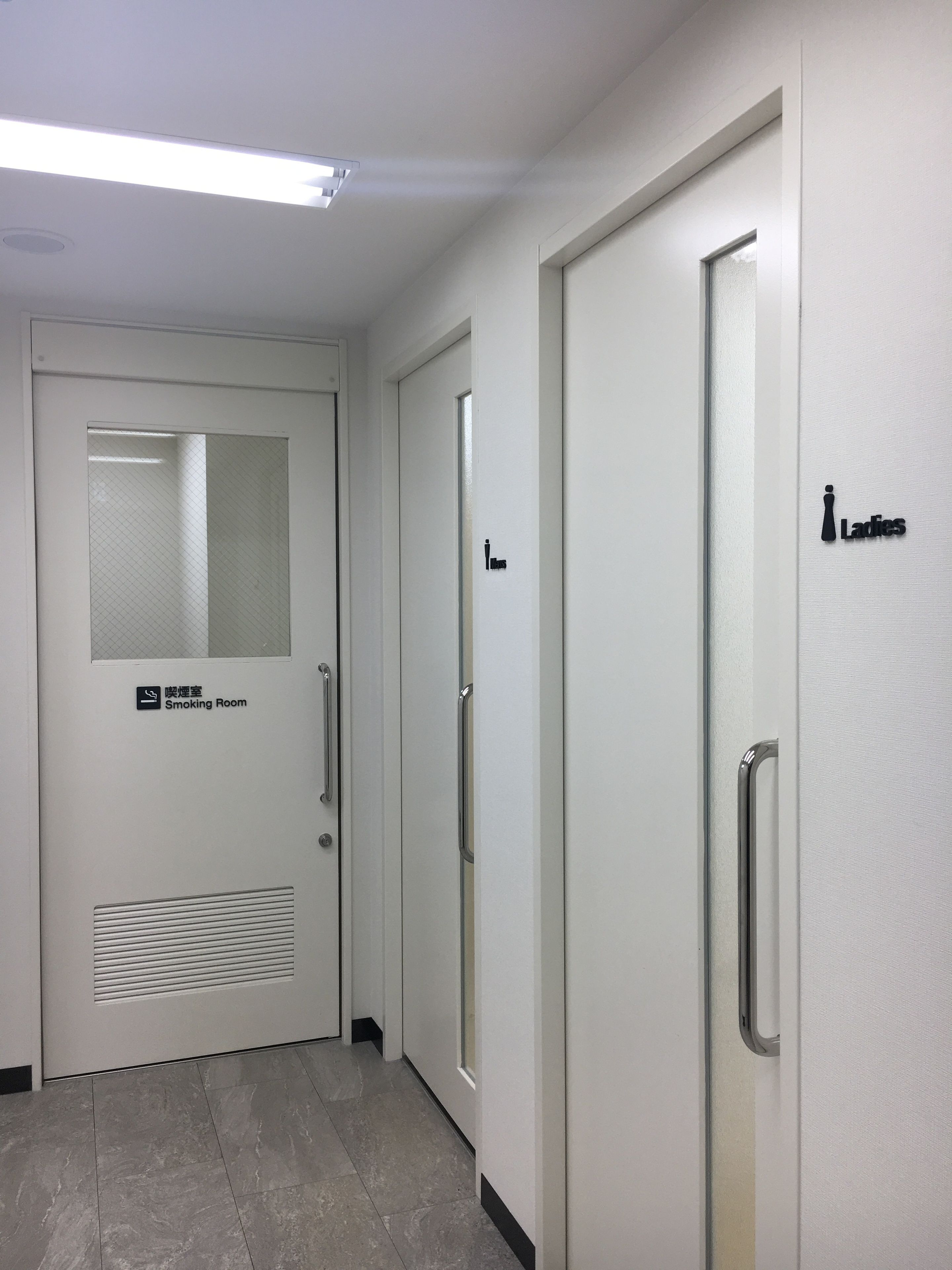 A hallway with a door labeled "Ladies" and another marked "Smoking Room."