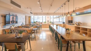 A modern dining area with long tables, chairs, and pendant lighting. - Shanghai Annshe Hotel (Shanghai)