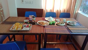 A dining table set with various dishes, a tray of snacks, and a thermos.