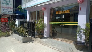 A building with a 'WELCOME' sign, a bus ticket gate, and a 'Royal Bird Thrash' sign.
