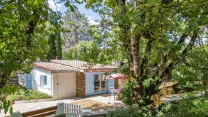 A rustic house with a tiled roof, stone walls, and a small patio with outdoor seating. - Cottage with River Views, Uzer (Uzer)