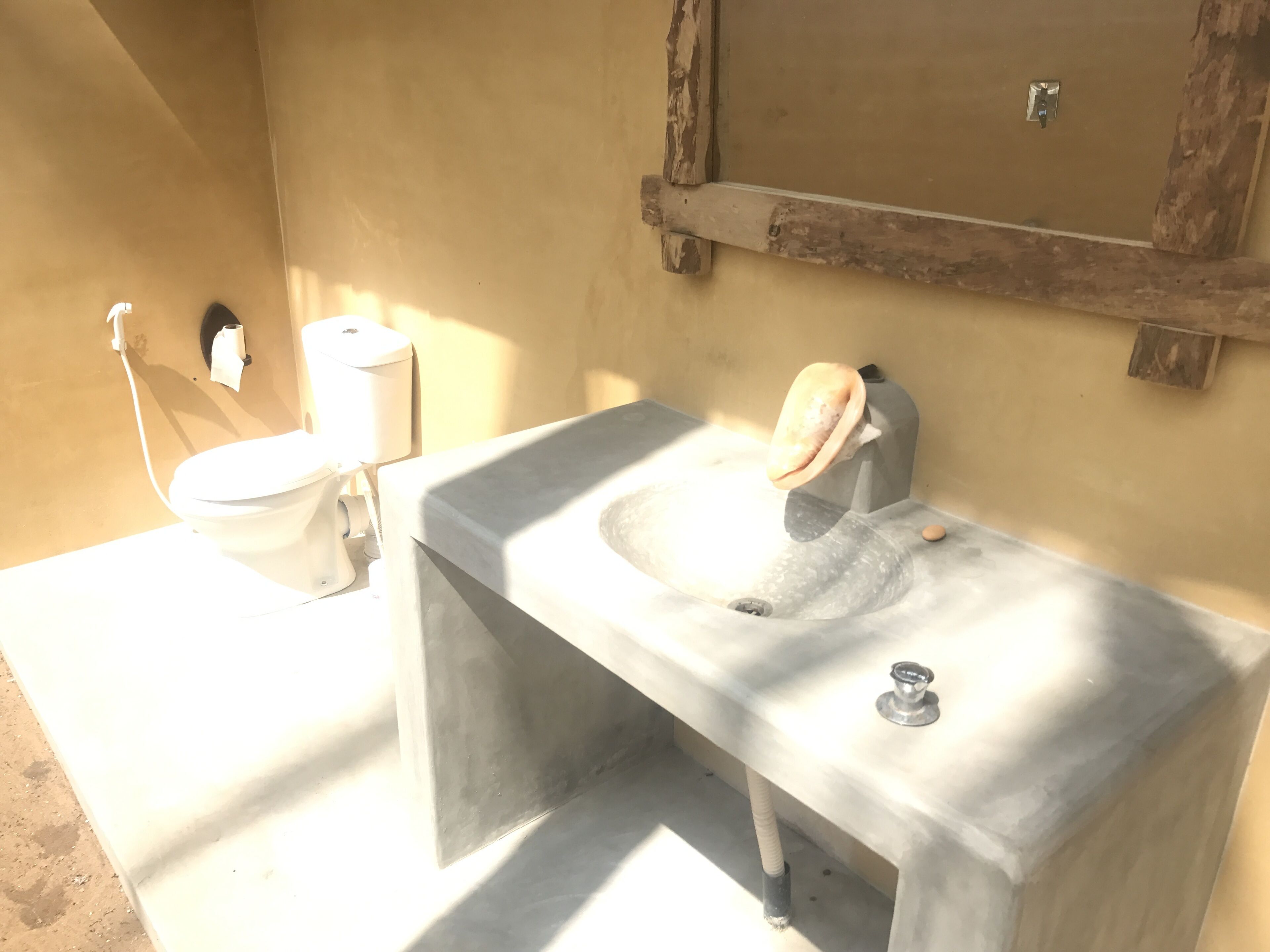 A bathroom with a white sink, a toilet, and a mirror.