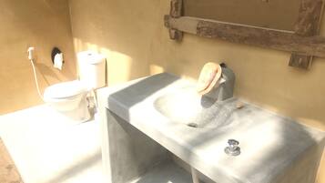 A bathroom with a white sink, a toilet, and a mirror.
