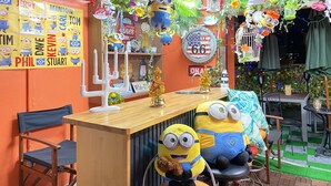A bar area with a wooden counter, a white candelabra, and a sign reading "USA California". - Orange House (Osaka)