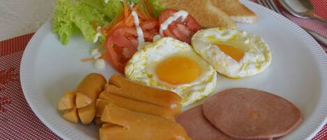 A plate of food with eggs, ham, and vegetables.