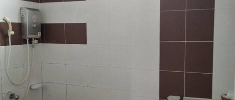 A bathroom with a shower, a sink, and a window.