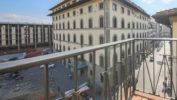 Ein Hotel mit mehrstöckiger Bauweise, großen Fenstern und einem Balkon mit Blick auf eine Straße.