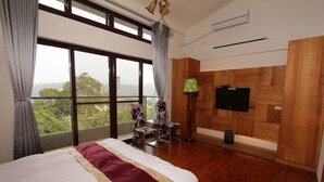 A hotel room with a large bed, a TV, a balcony with a chair, and a view of the outdoors. - Sanyi Sakura Resort (Sanyi)