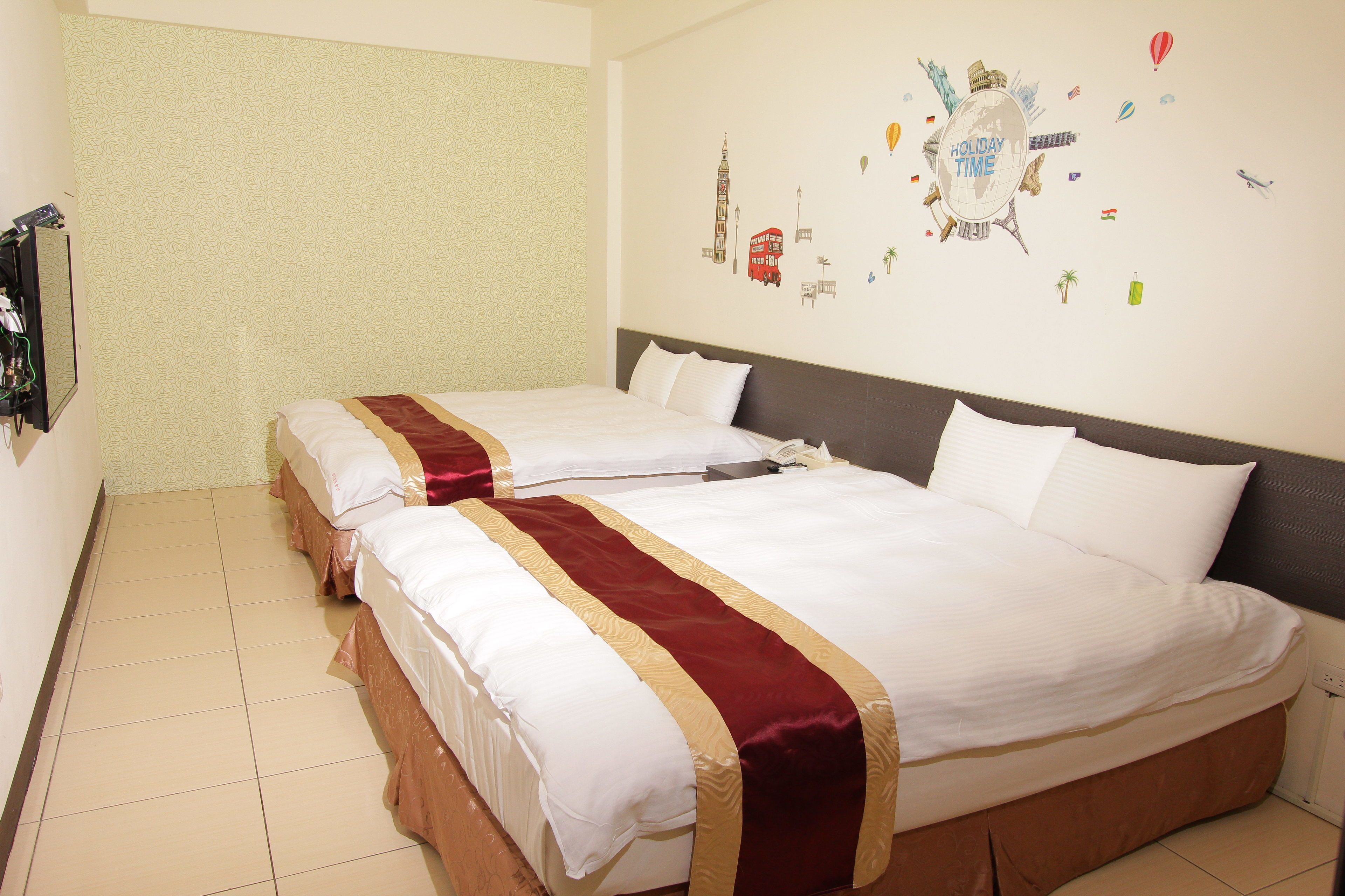 Ein Hotelzimmer mit zwei Betten, einem großen Wandbild und einer schlichten Wand an der Seite.