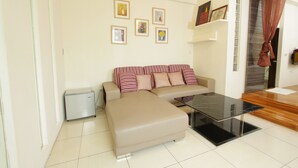 A modern living room with a sofa, a coffee table, and a refrigerator. - Sanyi Sakura Resort (Sanyi)