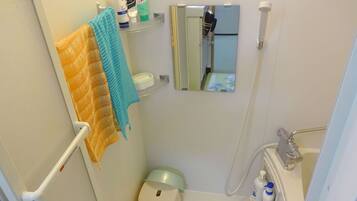 A bathroom with a towel rack, a mirror, a toilet, and a shower area.
