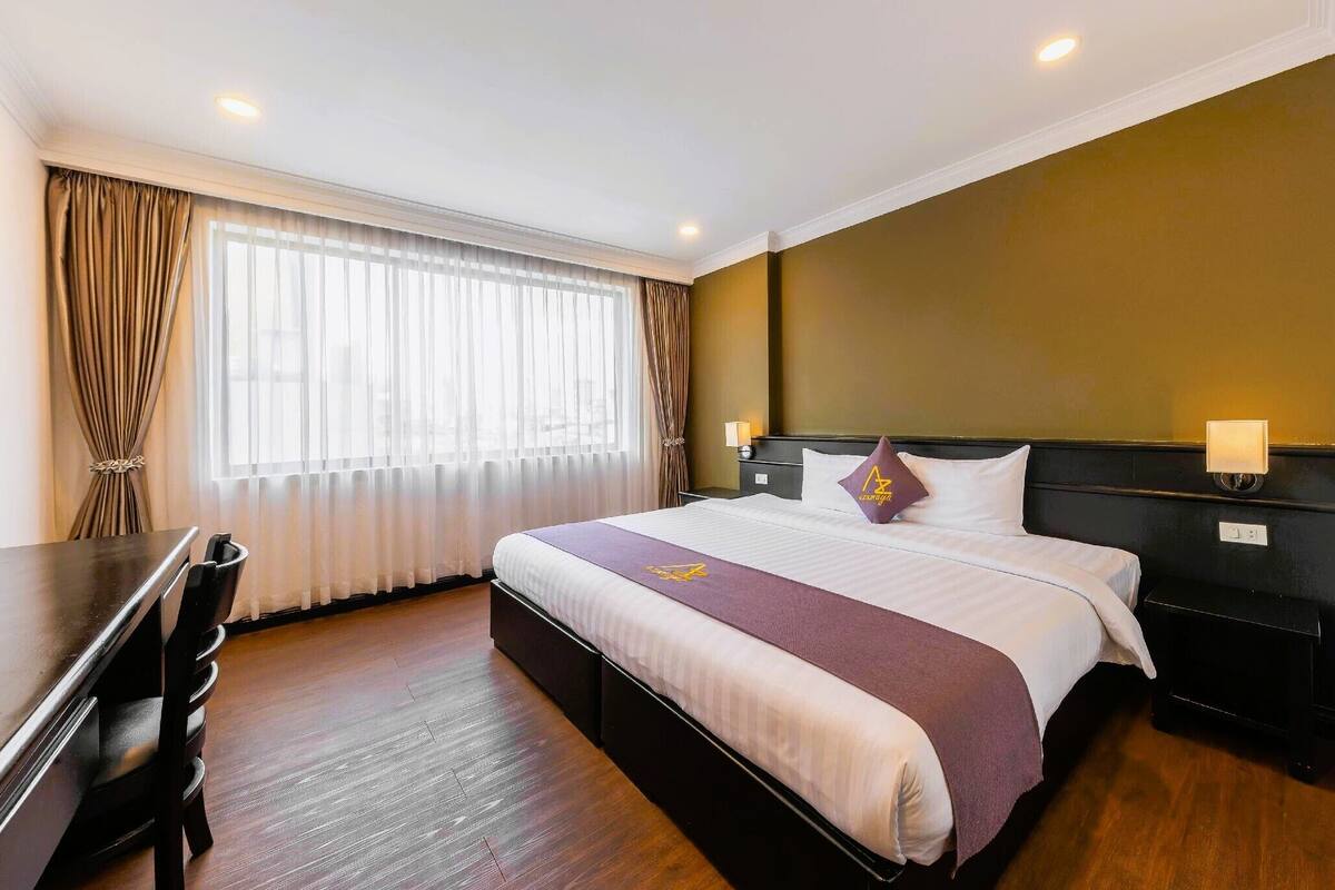 Ein Hotelzimmer mit Bett, Schreibtisch und Stuhl.