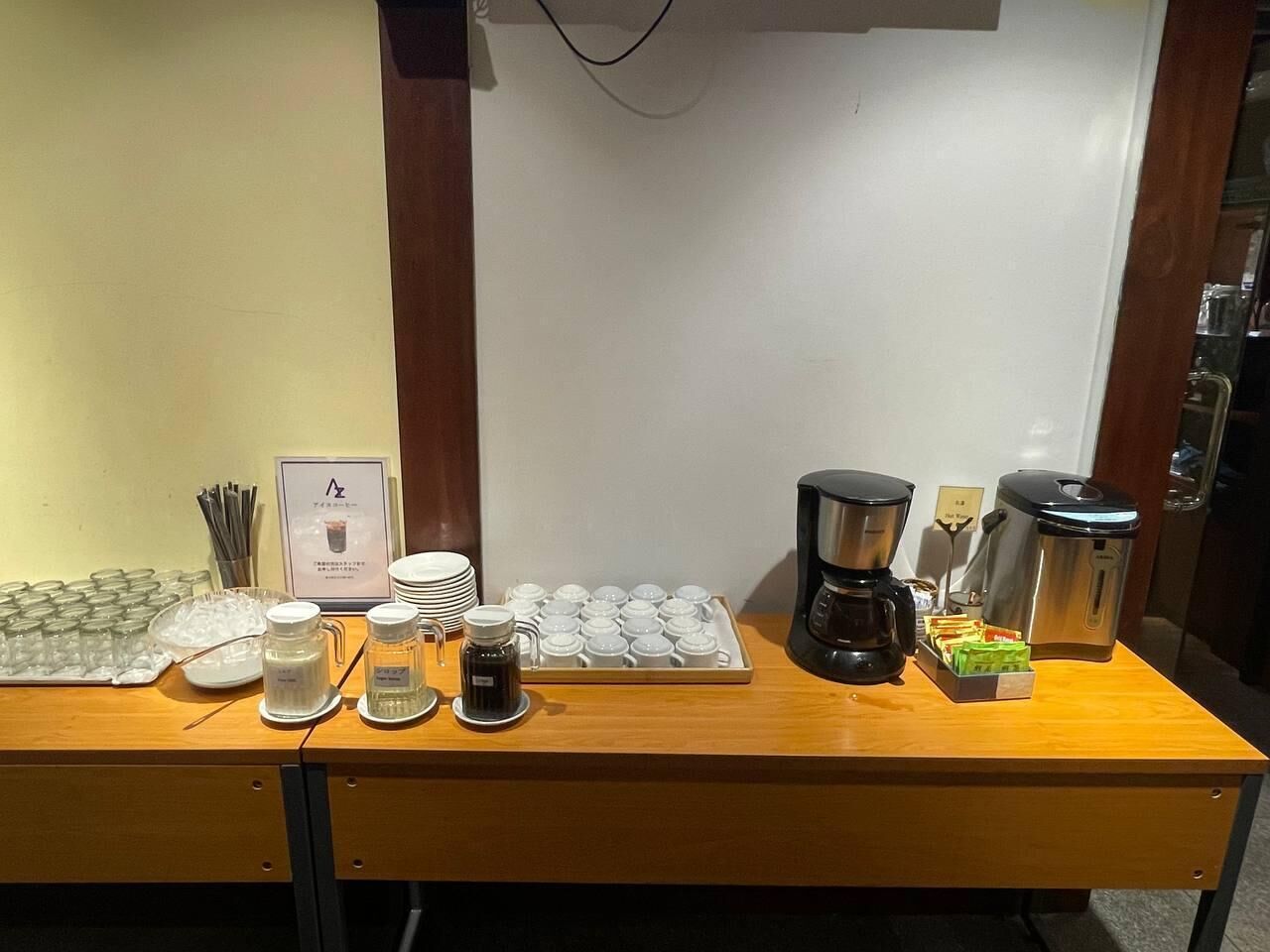 A breakfast buffet setup with coffee makers, tea dispensers, and a variety of food items.