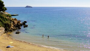 A beach with clear water, rocky outcrops, and a distant island. - Enjoy and relax with the light, the murmur of the sea and the fantastic views (San Juan de los Terreros)