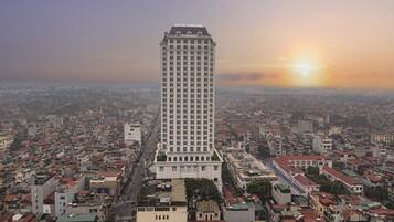 A tall hotel with a classic architectural design, surrounded by a densely packed urban area.
